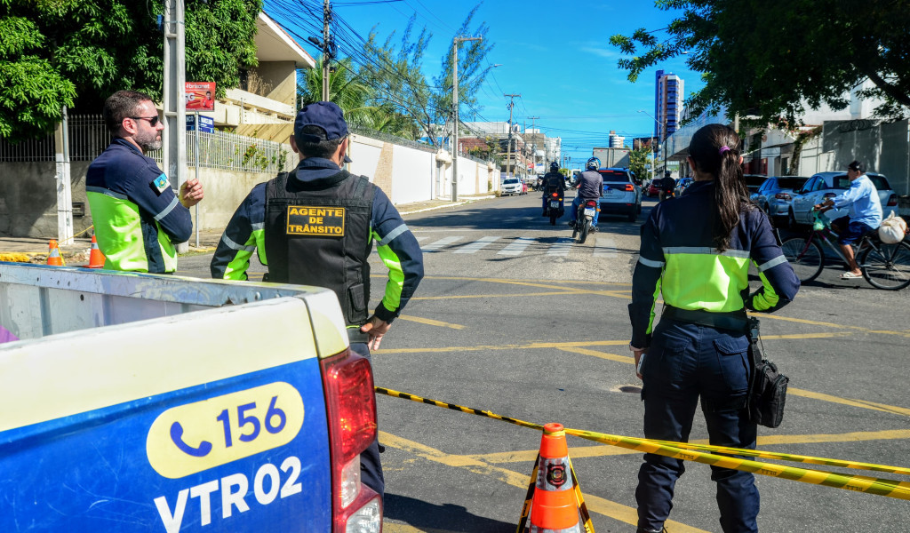 Agentes de trânsito ao lado de viatura e cones em uma rua de Mossoró
