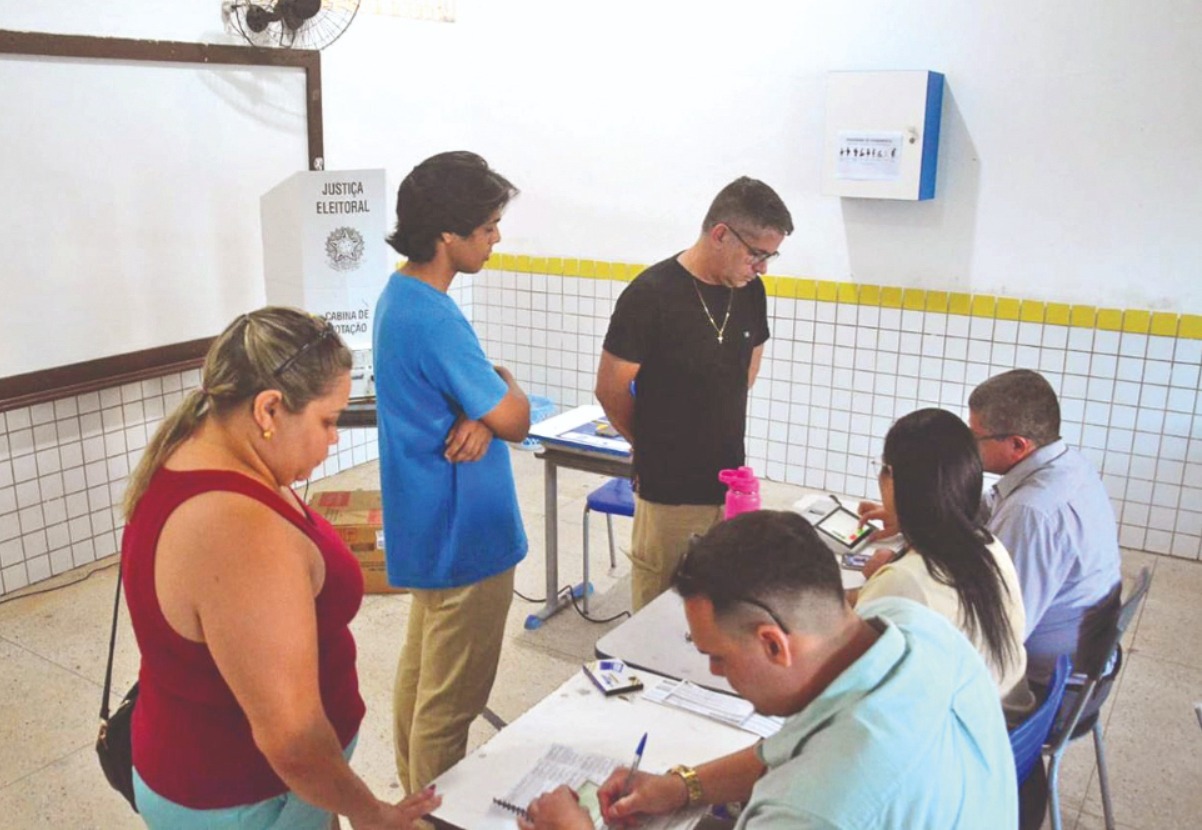 Eleitores e mesários em uma seção eleitoral durante a votação