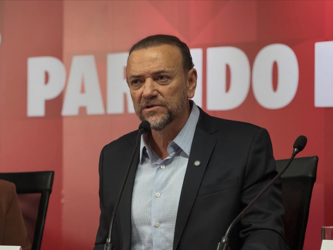 Edinho Silva fala ao microfone diante de painel vermelho com identificação do Partido dos Trabalhadores